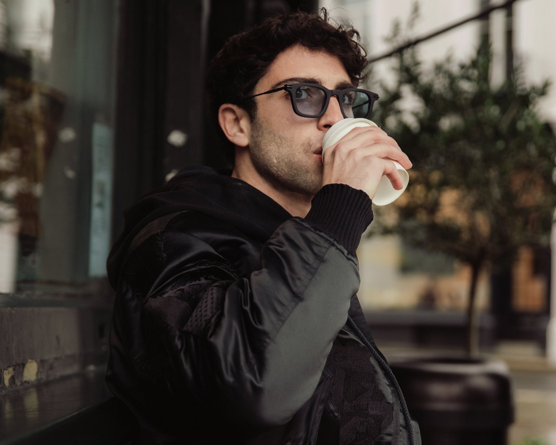 Man drinking from a paper cup outdoors